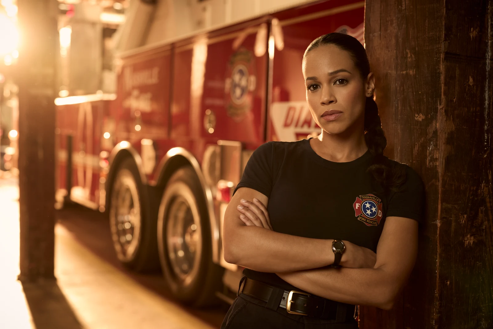 Official ABC promotional photo of a Nashville Fire Department firefighter from 9-1-1: Nashville standing beside a fire engine.