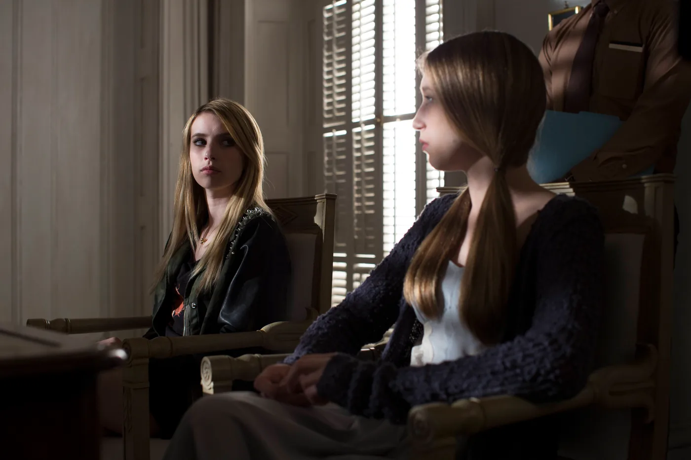 Two young witches sit inside Miss Robichaux's Academy in an official Coven publicity photograph.