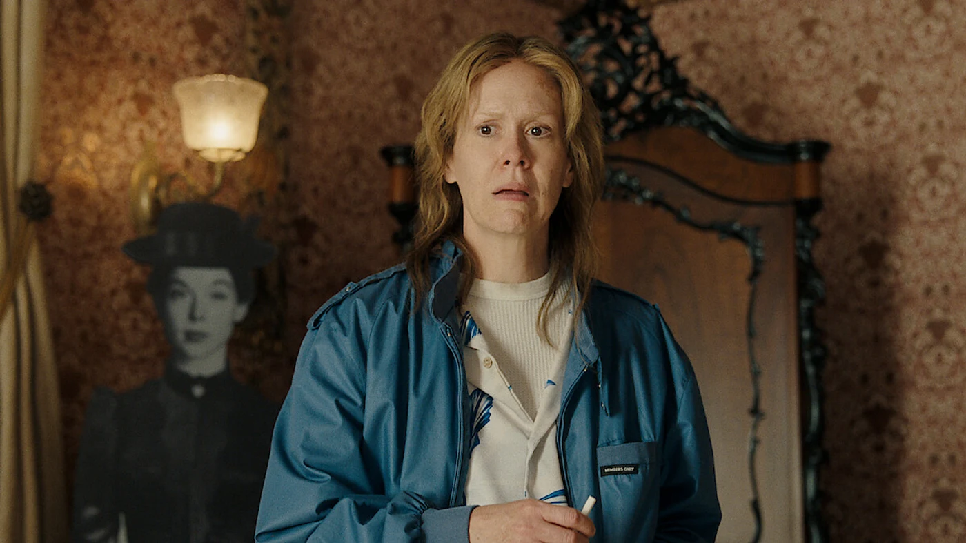 Sarah Paulson as Aileen Wuornos standing in the Lizzie Borden house, with a cardboard cutout of Lizzie Borden visible in the background, in Netflix's Monster: The Lizzie Borden Story.
