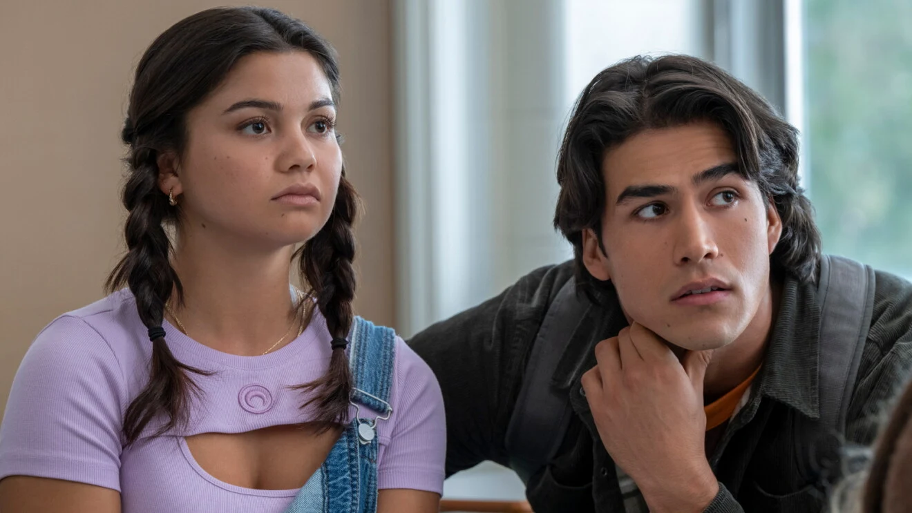 Siena Agudong as Sue Snell and Joel Oulette as Tommy Ross sitting close together in a school interior.