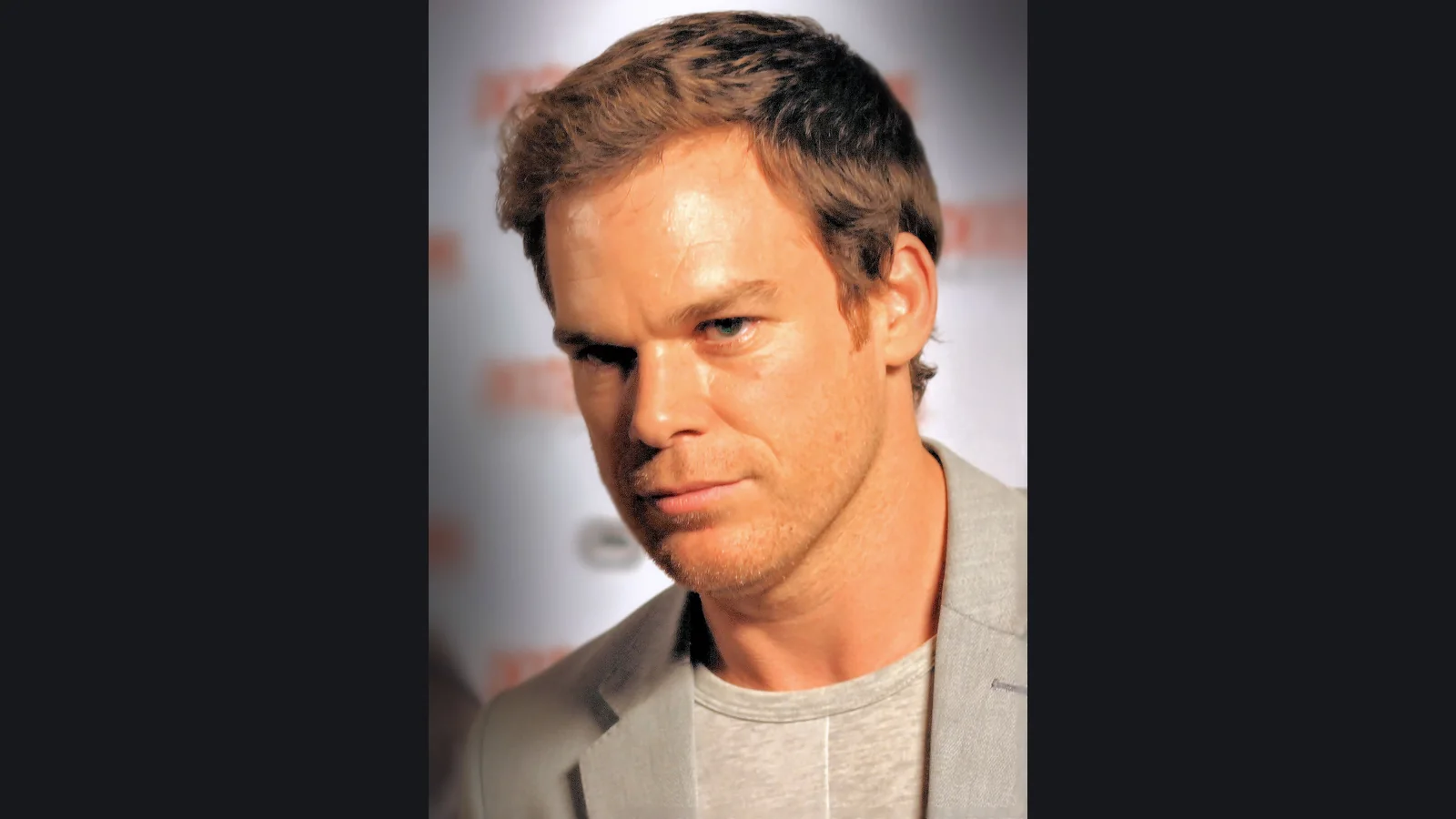 Archive photograph of Michael C. Hall at Comic-Con in 2011, contained within a dark neutral frame.