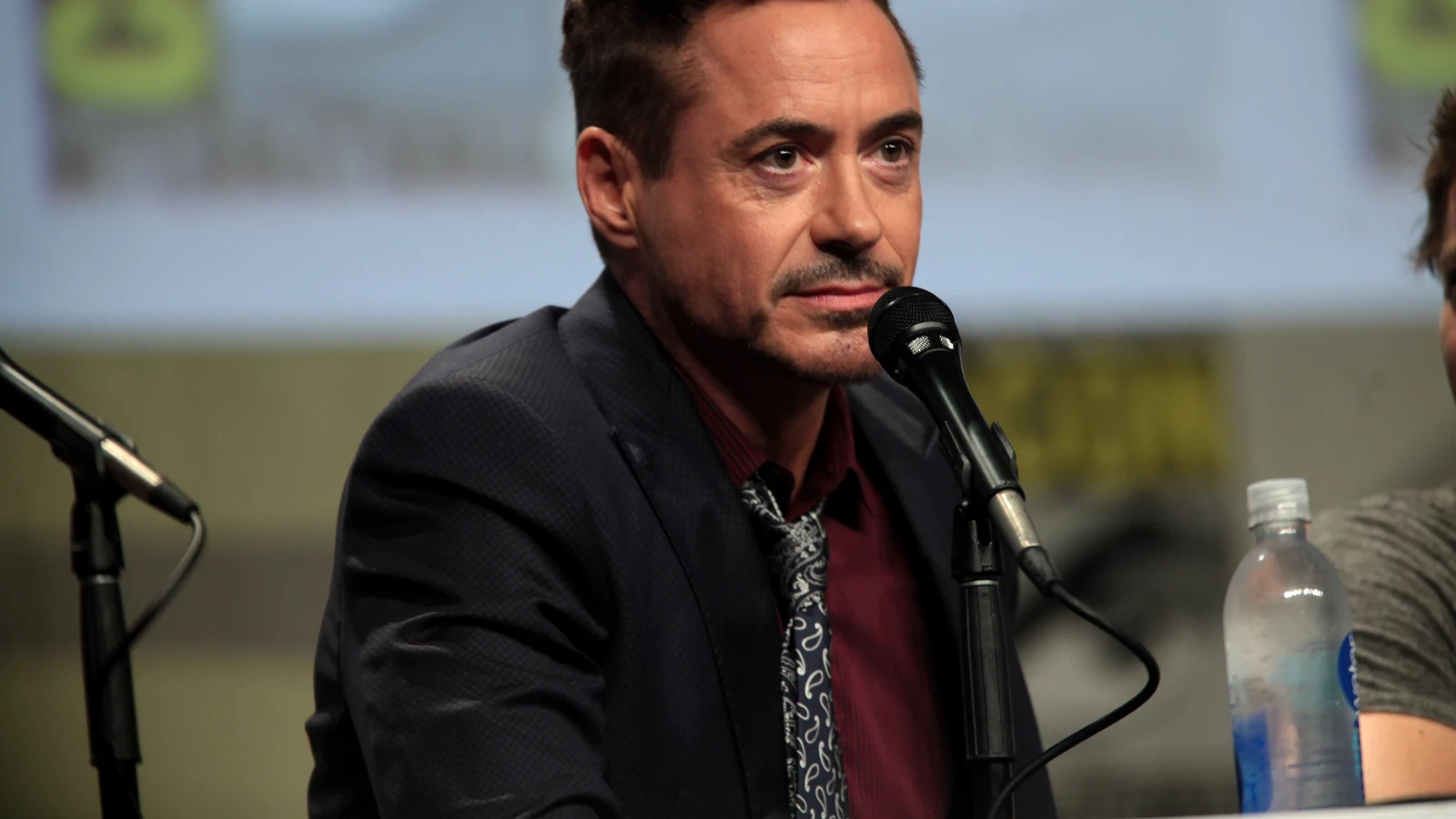 Robert Downey Jr. speaking into a microphone at San Diego Comic-Con in 2014.