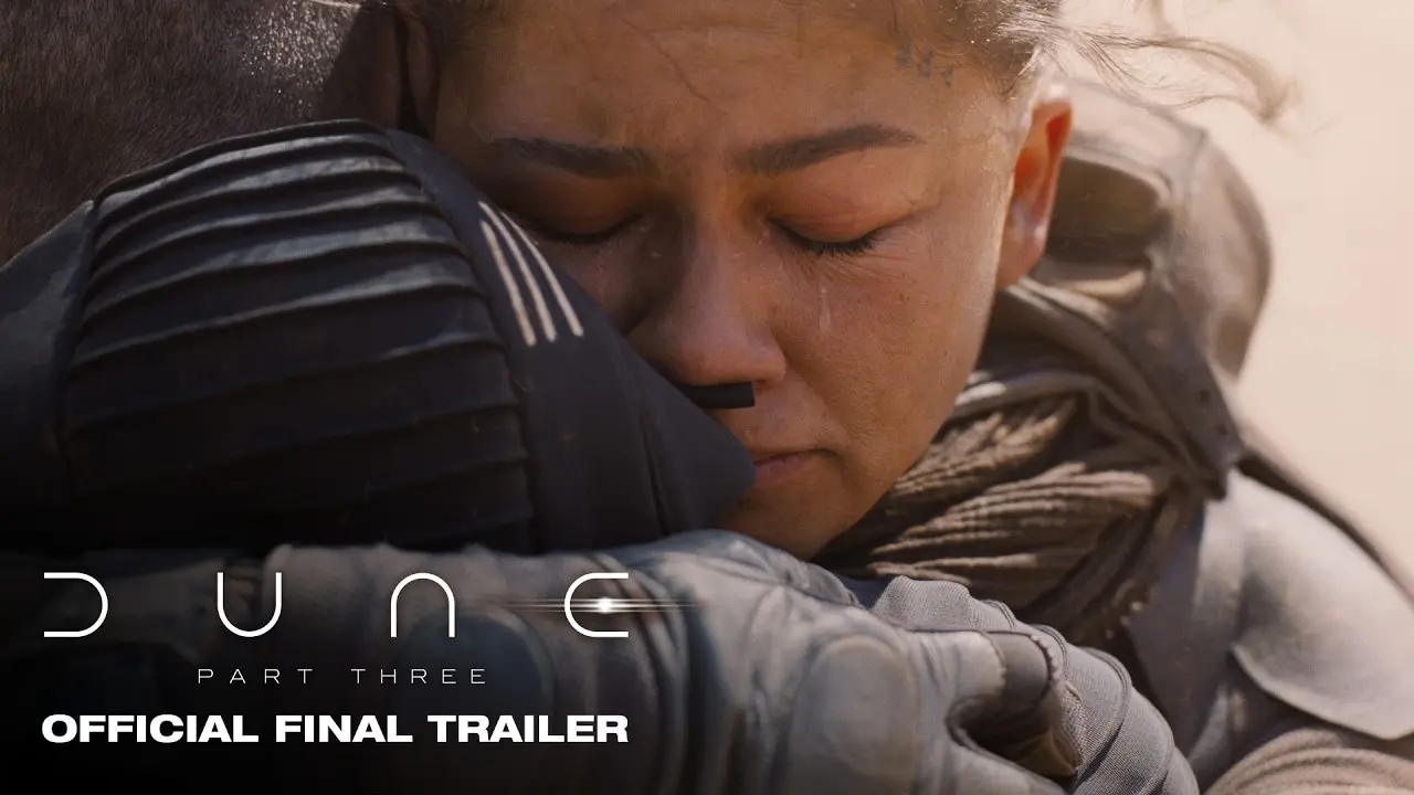 Zendaya as Chani, eyes closed and tearful, held in an embrace by a figure in a dark stillsuit, on Warner Bros.' official final trailer card for Dune: Part Three.