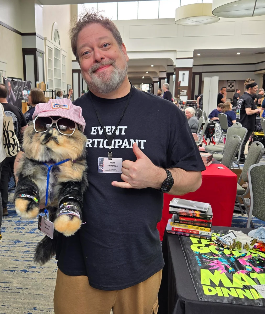 Matt Dinniman at AuthorCon, holding a Princess Donut plush toy.