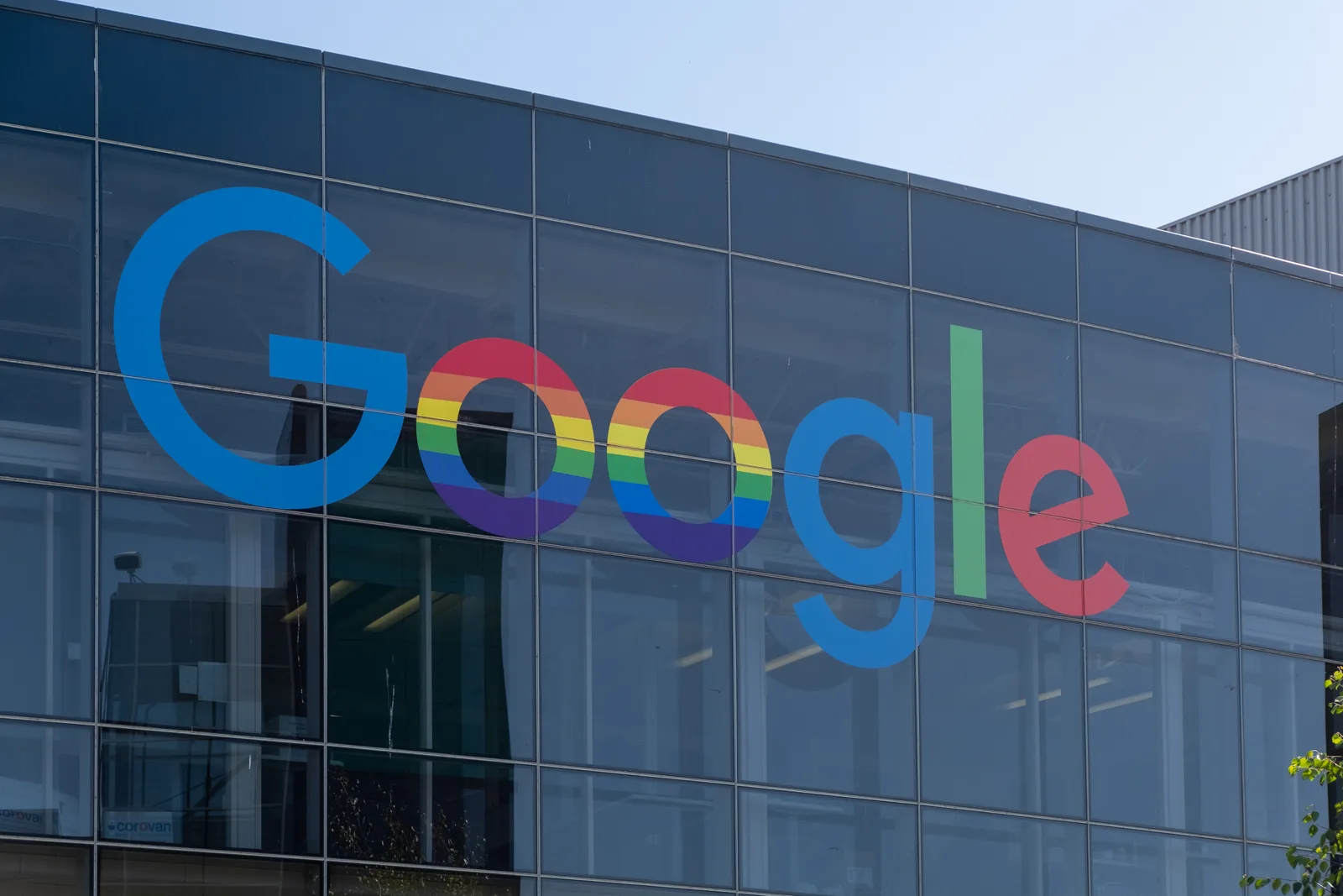 A large multicolored Google logo across the glass exterior of a campus building.