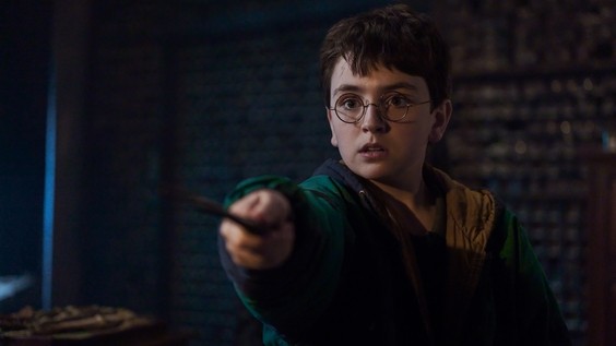 Dominic McLaughlin as Harry Potter casting a spell with his wand, from HBO's official September 2026 Philosopher's Stone press materials.