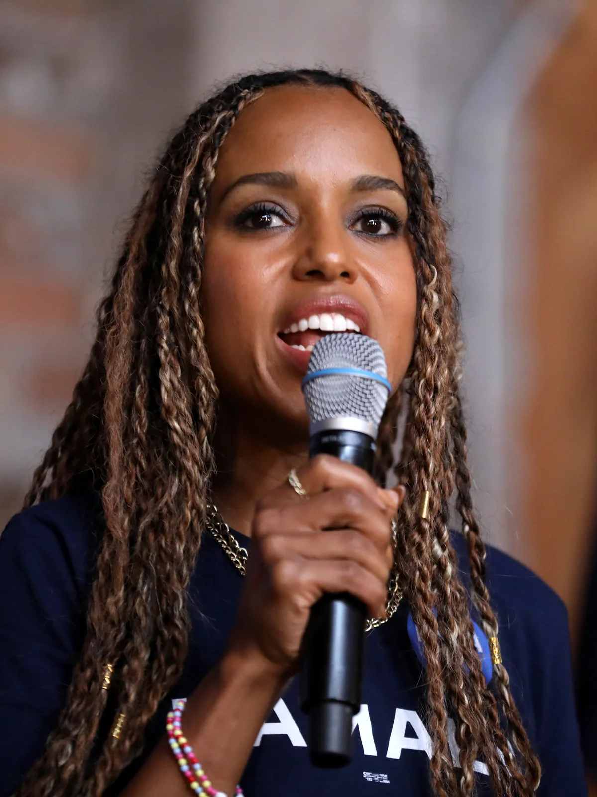 Kerry Washington with long braids holding a microphone in an archive portrait taken in Phoenix in 2024.