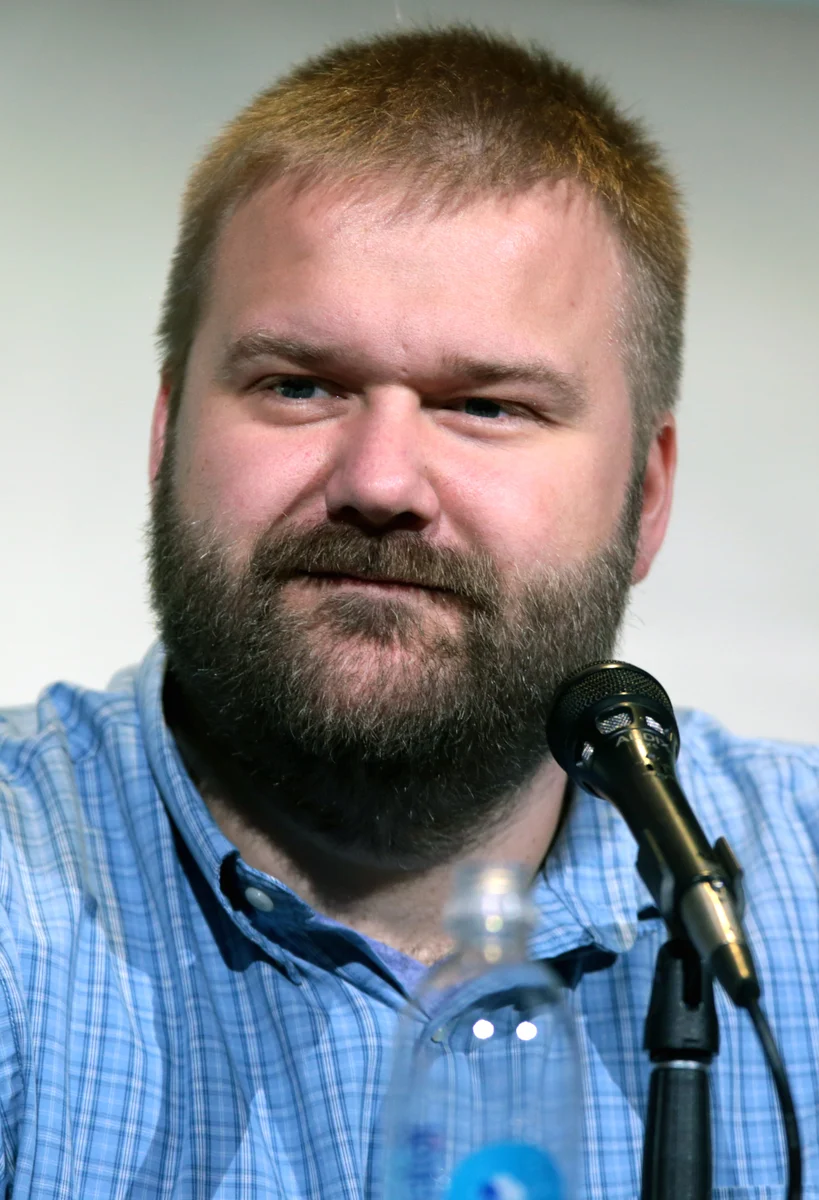 Invincible co-creator Robert Kirkman speaking into a microphone at San Diego Comic-Con.