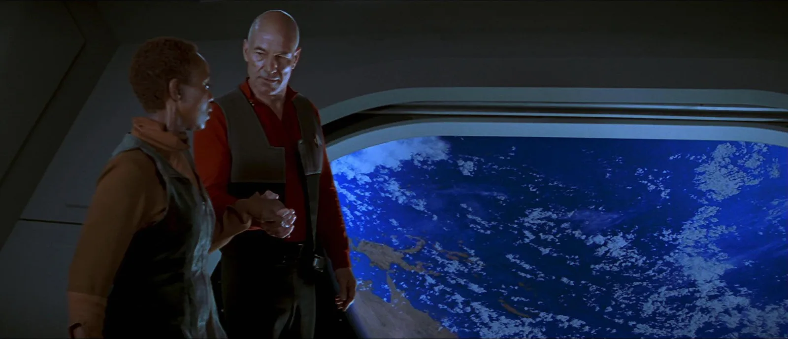 Picard and Lily Sloane standing at a window above Earth aboard the Enterprise-E in Star Trek: First Contact.