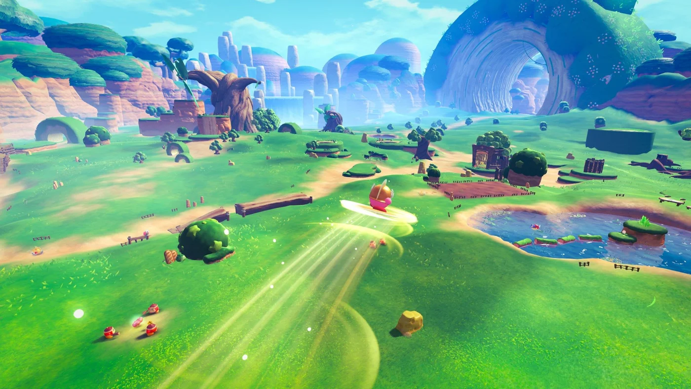 Kirby and the World Beyond gameplay screenshot showing Kirby using a Parasol ability to glide across a sprawling green field toward a distant stone archway.