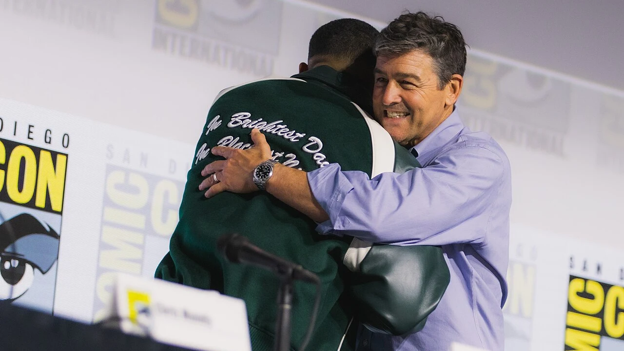 Aaron Pierre, seen from behind, embracing Kyle Chandler at San Diego Comic-Con in 2026.