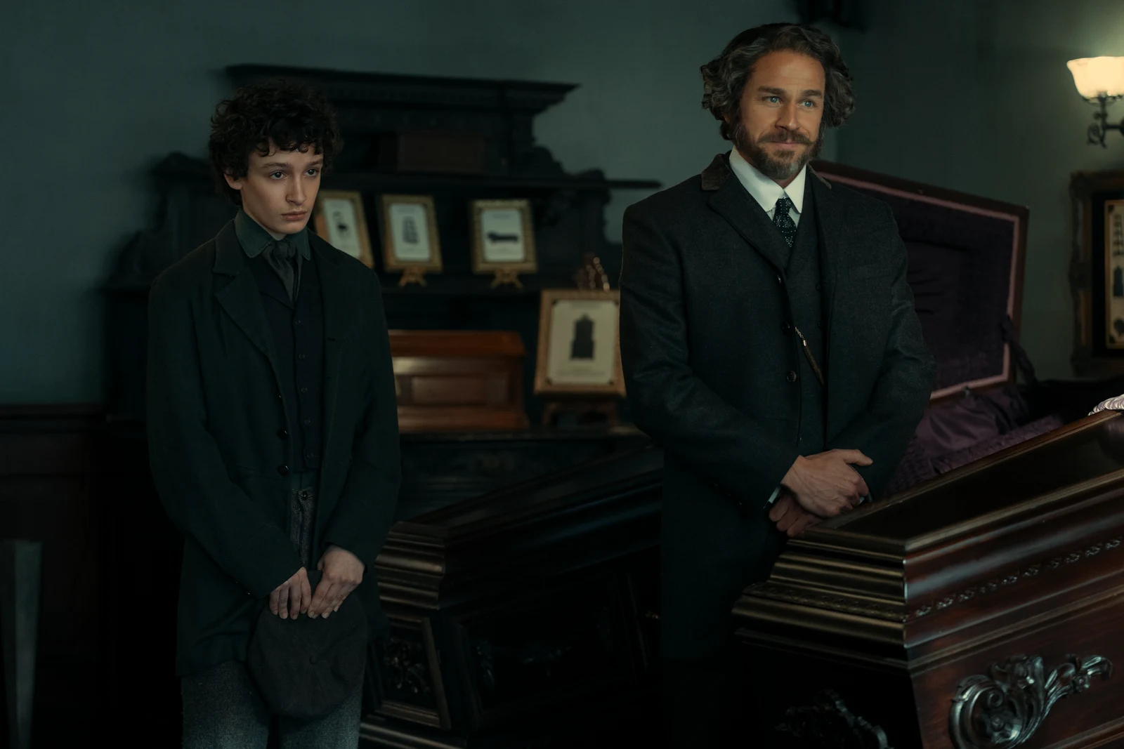Charlie Hunnam as Andrew Borden in Netflix's Monster: The Lizzie Borden Story, standing beside an open casket in his undertaking business.