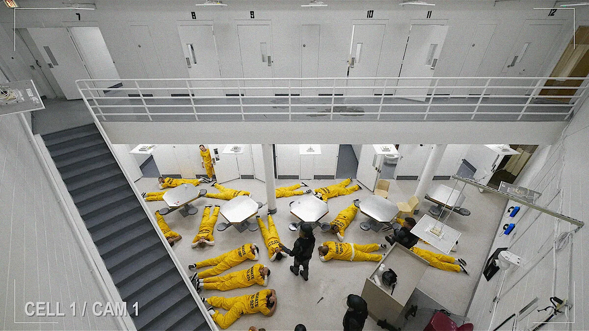 Overhead Netflix publicity still of participants in yellow uniforms inside the prison used for The New Stanford Prison Experiment.