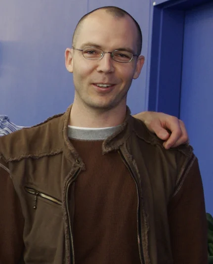 Jonathan Blow wearing glasses and a brown shirt at a games-industry event.
