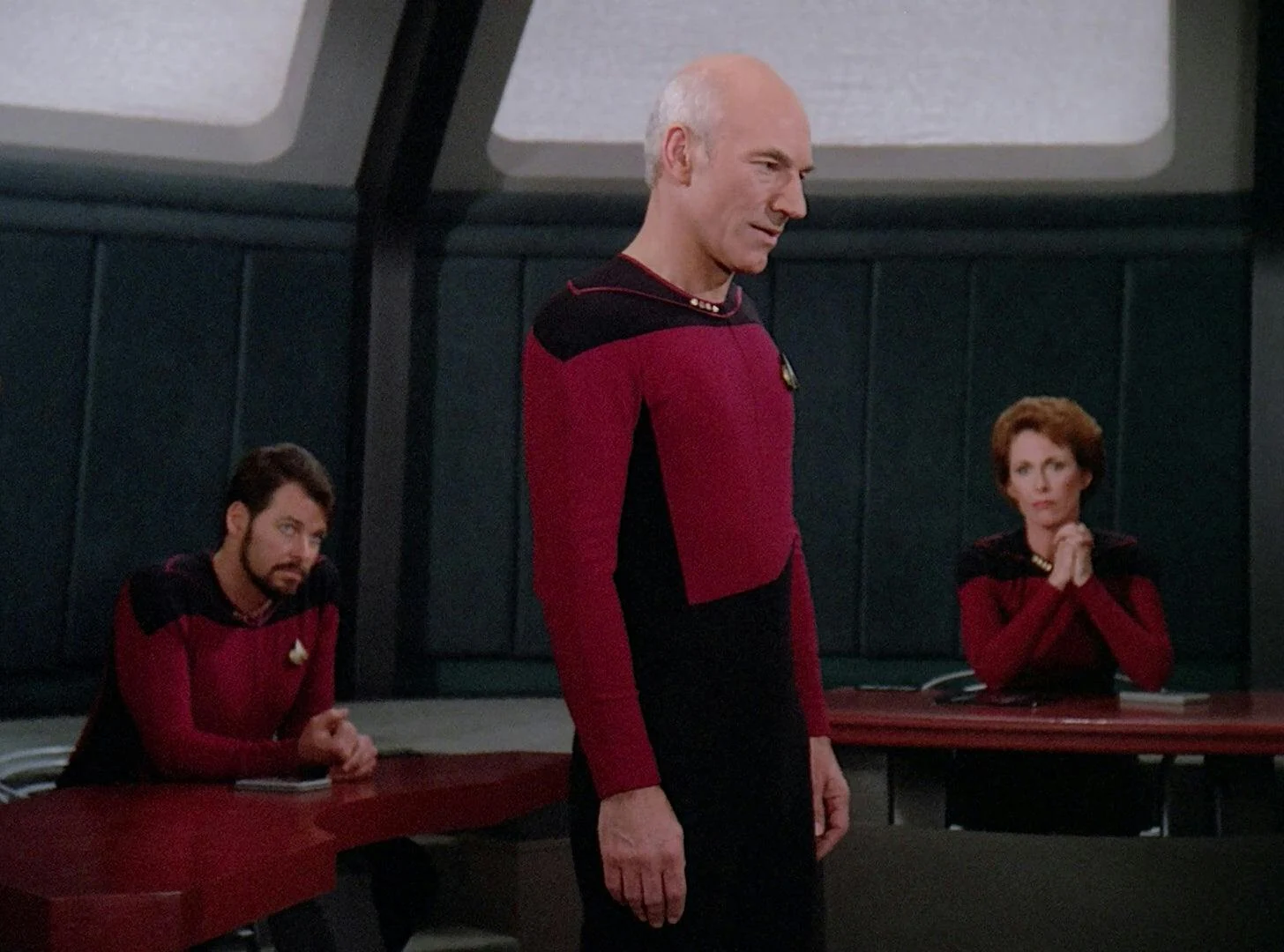 Patrick Stewart as Captain Picard addresses the hearing in The Measure of a Man, with William Riker and Phillipa Louvois seated behind him.