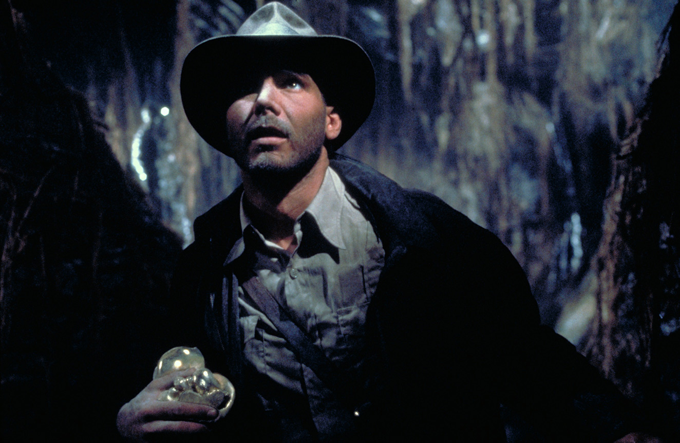 Harrison Ford as Indiana Jones inside a temple in an official Lucasfilm still from Raiders of the Lost Ark.