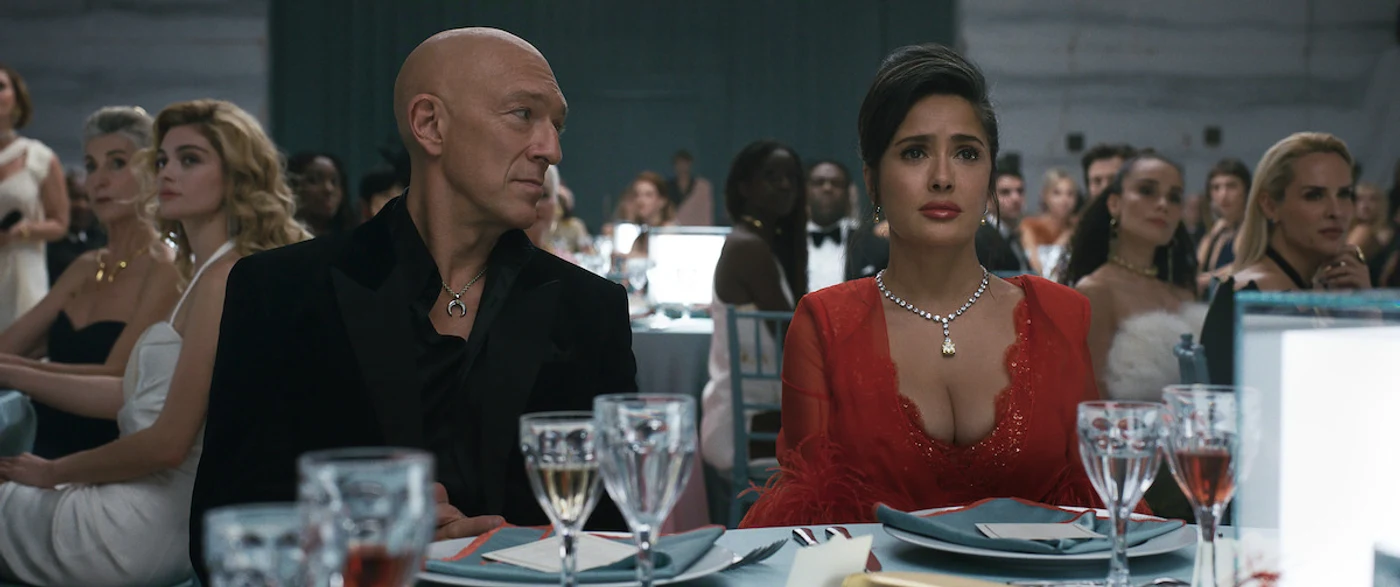 Vincent Cassel as Ben Bracken and Salma Hayek Pinault as Gloria Bracken seated at the gala in Netflix's Sacrifice.