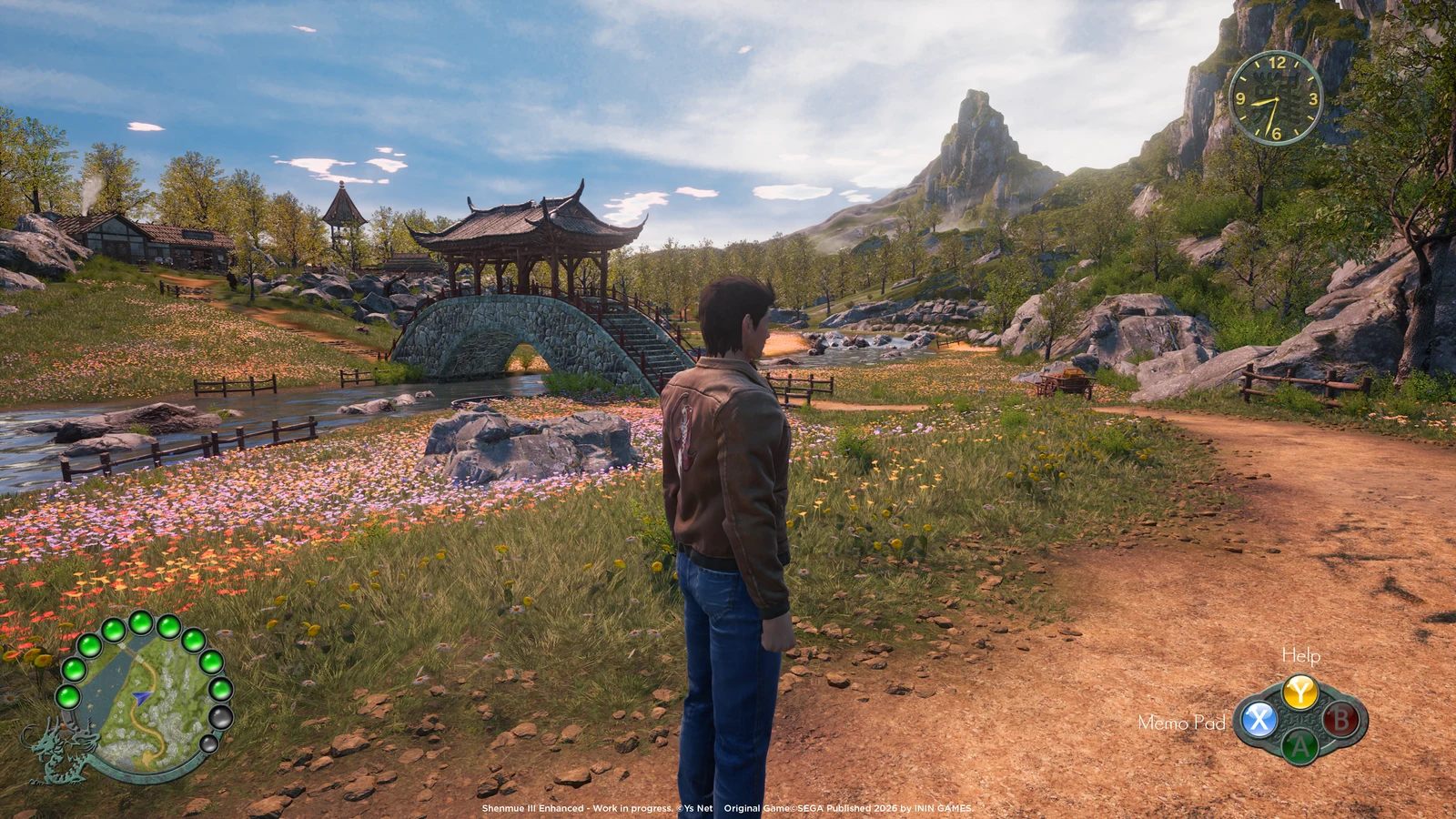 Ryo Hazuki stands beside a path and a covered stone bridge in an official Shenmue III Enhanced work-in-progress screenshot.