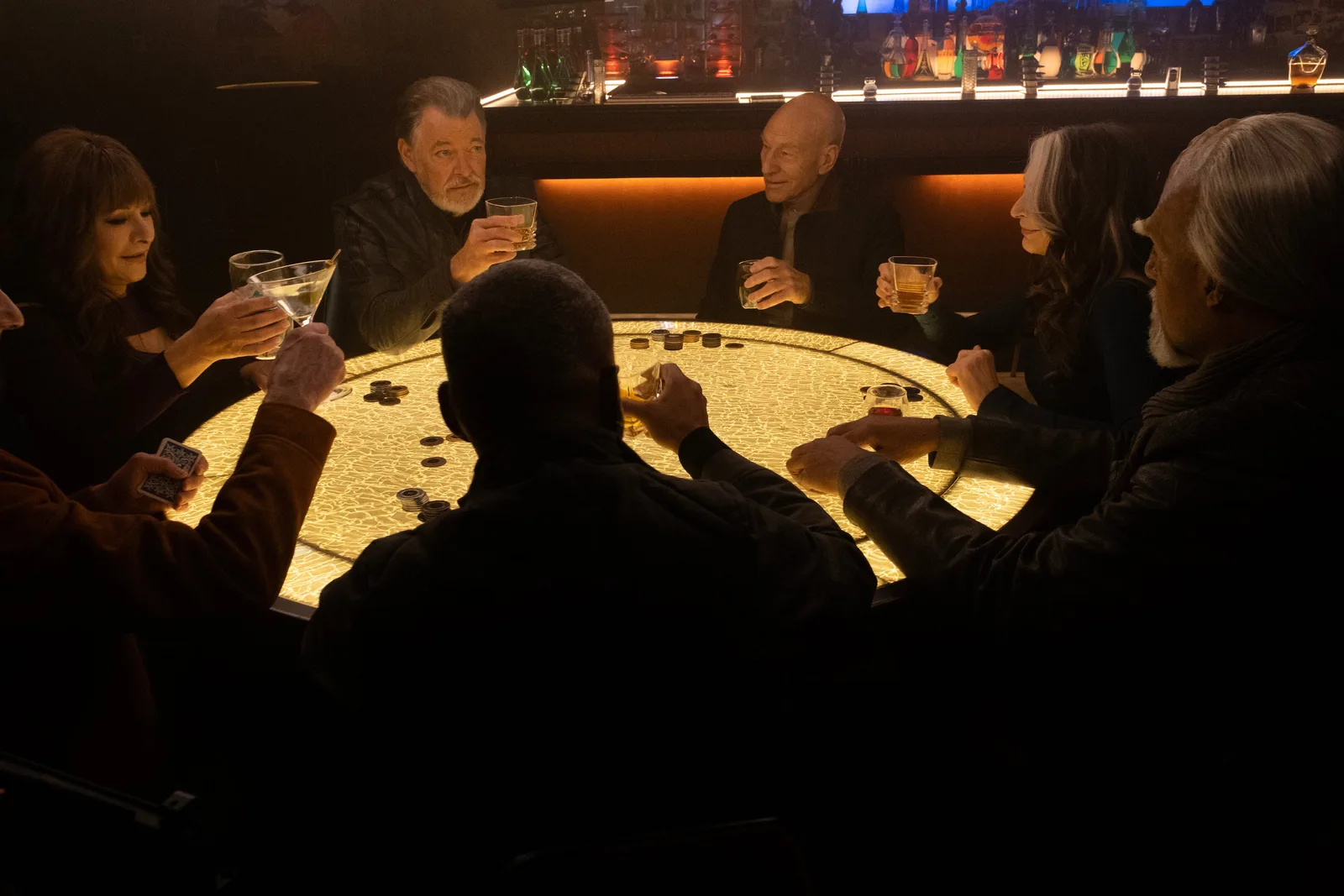 The Enterprise-D crew gathered around a glowing poker table in a bar in the Star Trek: Picard series finale.