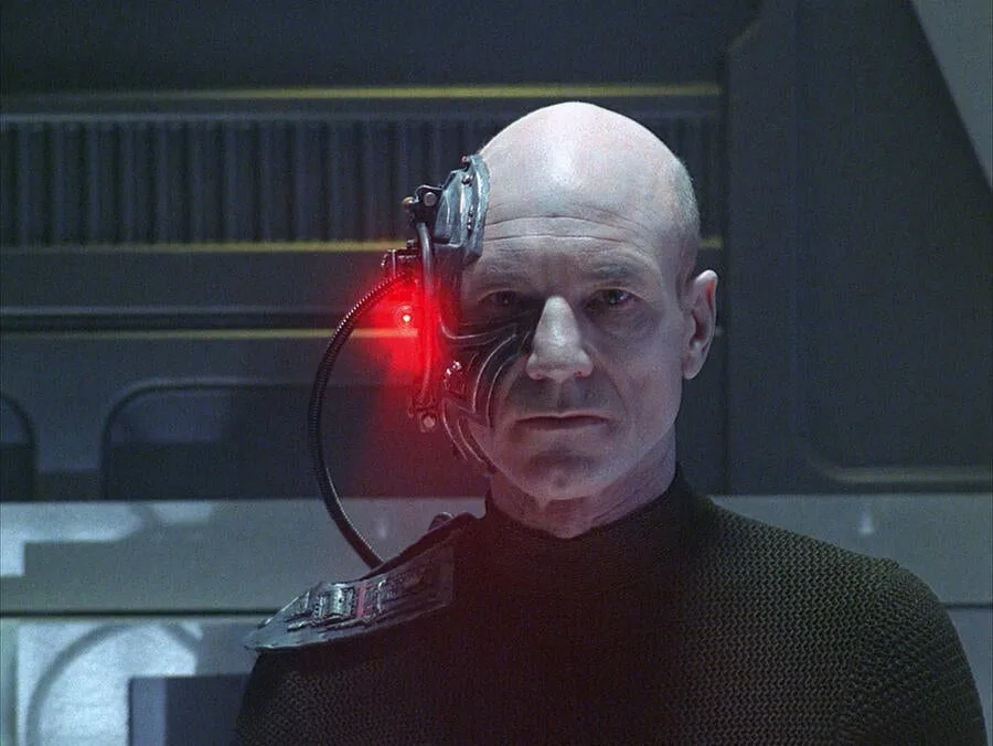 Captain Picard as Locutus of Borg, with a red-lit cybernetic implant over one eye.