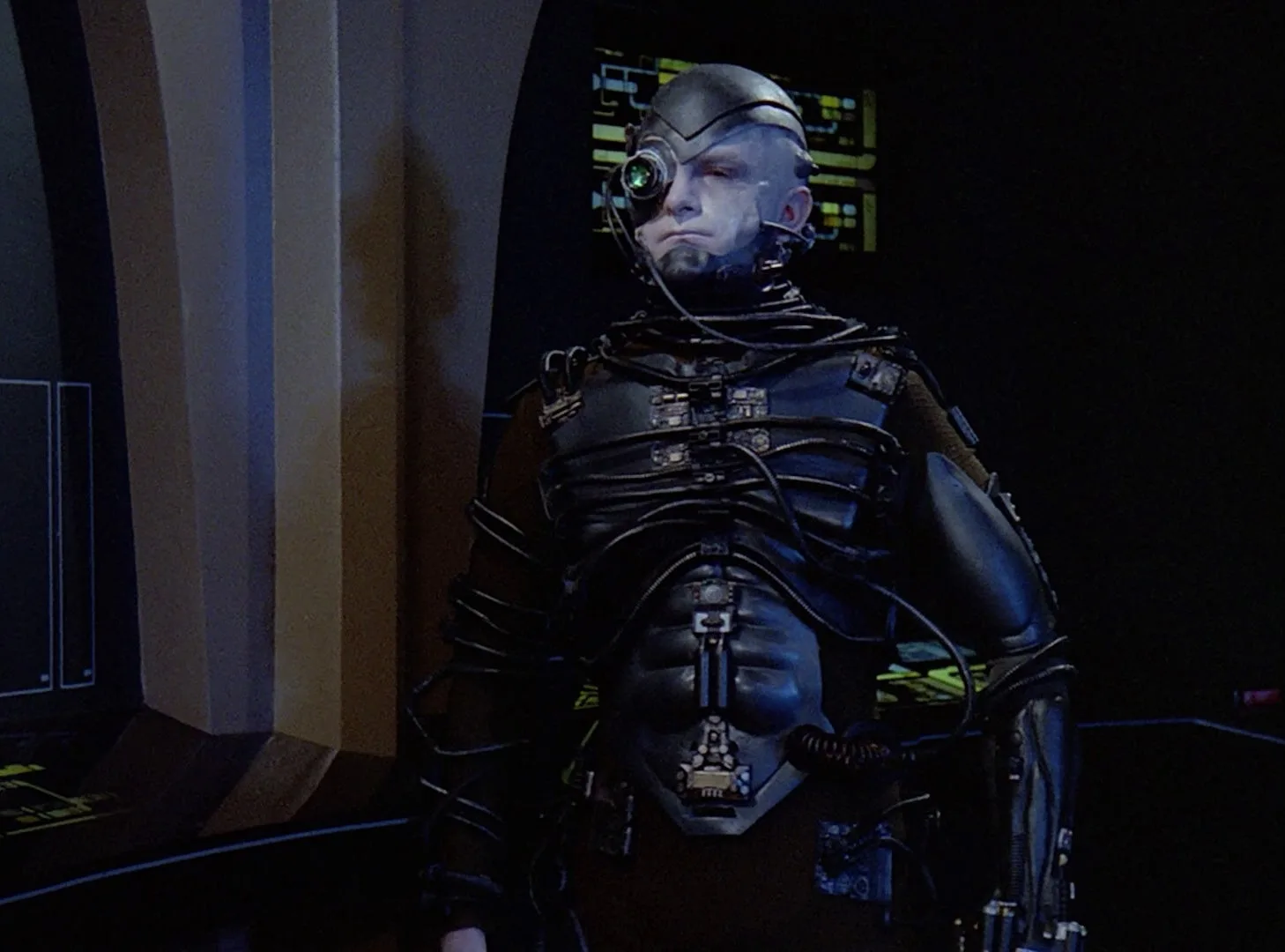 A Borg drone stands in a darkened corridor aboard the Enterprise in the TNG episode Q Who.