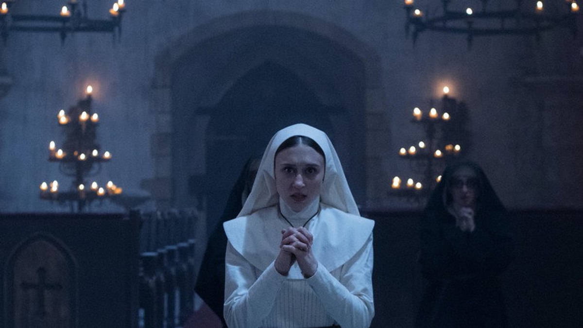 Taissa Farmiga as Sister Irene praying in the abbey chapel in The Nun (2018).