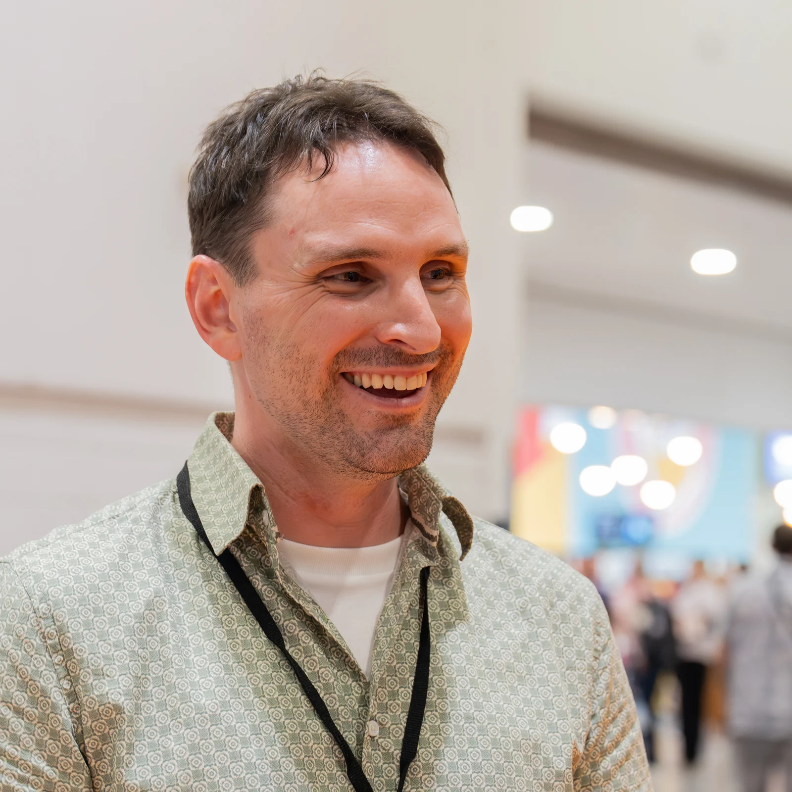 Composer Evan Call smiling at MCM Comic Con London in May 2026, wearing a patterned green shirt.