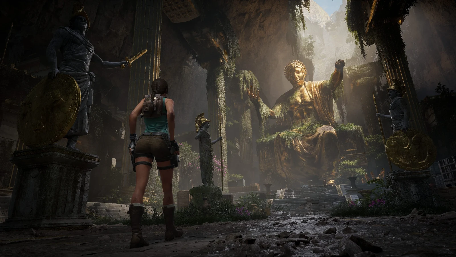Lara Croft standing before a towering golden statue inside an ancient Greek ruin in Tomb Raider: Legacy of Atlantis.